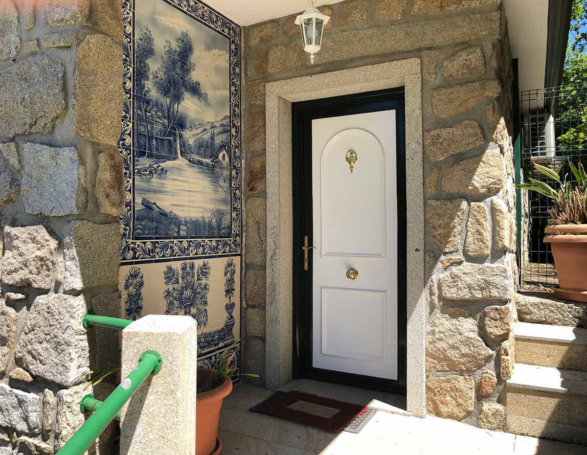 Vista de la puerta de entrada a la casa de Villa Catarina, con un mosaico en azulejo en un lateral.
